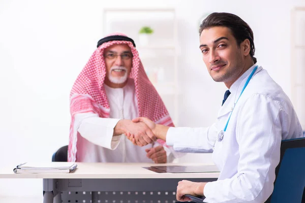 Old male arab visiting young male doctor — ストック写真