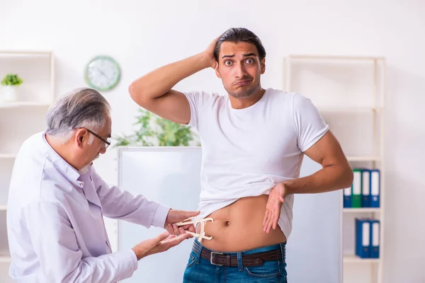 Médico dietista dando consejos a pacientes con sobrepeso de grasa — Foto de Stock