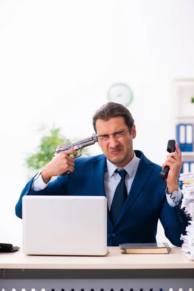 Jonge mannelijke werknemer ongelukkig met overmatig werk — Stockfoto