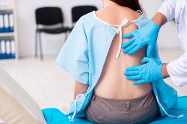 Yaralı genç kadın genç erkek doktoru ziyaret ediyor.