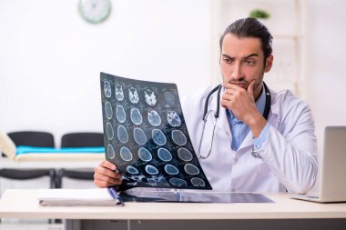 Klinikte çalışan yakışıklı genç erkek doktor.