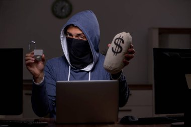 Erkek bilgisayar korsanı, güvenlik duvarını geç saatlerde hackliyor.