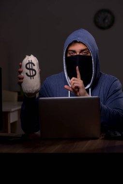 Erkek bilgisayar korsanı, güvenlik duvarını geç saatlerde hackliyor.