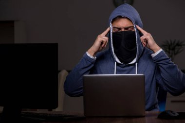 Erkek bilgisayar korsanı, güvenlik duvarını geç saatlerde hackliyor.