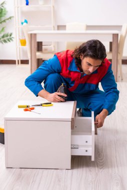 Genç erkek marangoz içeride çalışıyor.