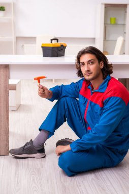 Genç erkek marangoz içeride çalışıyor.