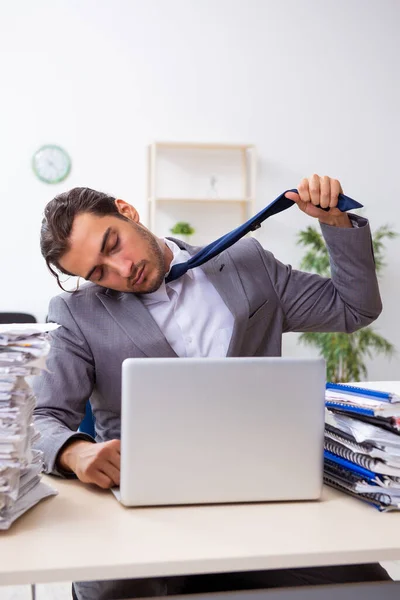 Jonge mannelijke werknemer ongelukkig met overmatig werk — Stockfoto