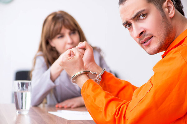 Молодой человек встречается с адвокатом в предварительном заключении