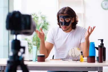 Genç erkek kozmetikçi blogu için video kaydediyor.