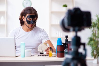 Genç erkek kozmetikçi blogu için video kaydediyor.