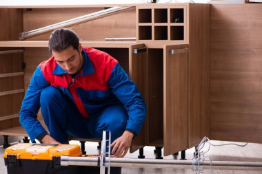 Genç yakışıklı erkek marangoz içeride çalışıyor.