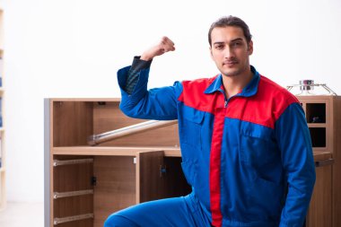 Genç yakışıklı erkek marangoz içeride çalışıyor.