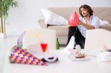 Genç adam doğum gününü evde kutluyor.