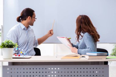 Genç bayan öğrenci ve erkek öğretmen sınıfta.