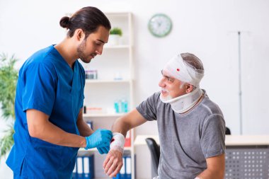 İlk yardım konseptinde genç erkek doktor ve yaşlı hasta.