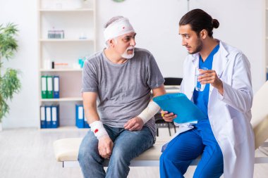 İlk yardım konseptinde genç erkek doktor ve yaşlı hasta.