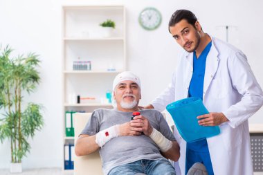 İlk yardım konseptinde genç erkek doktor ve yaşlı hasta.