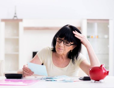 Faturalarını ödemeye çalışan olgun bir kadın.