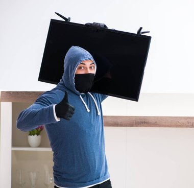 Hırsız evden televizyon çalıyor.