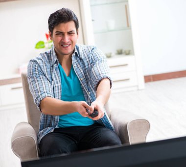 Evde televizyon izleyen bir adam.