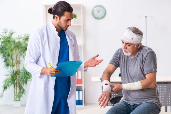 İlk yardım konseptinde genç erkek doktor ve yaşlı hasta.