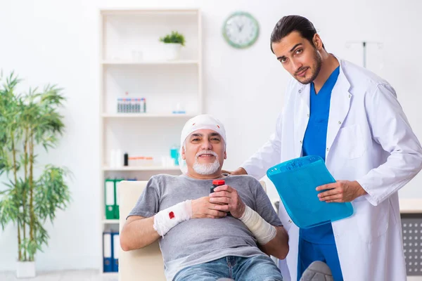 İlk yardım konseptinde genç erkek doktor ve yaşlı hasta. — Stok fotoğraf