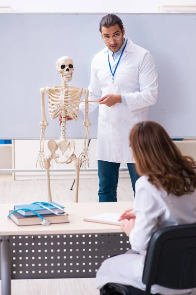 Jovem professor médico, esqueleto e estudante do sexo feminino no cl — Fotografia de Stock