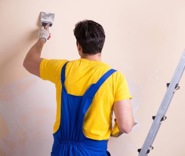 Duvara alçı yapıştıran genç müteahhit.