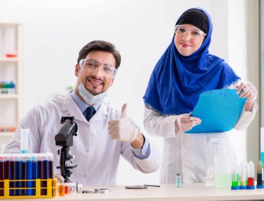 Laboratuvarda çalışan iki kimyager.