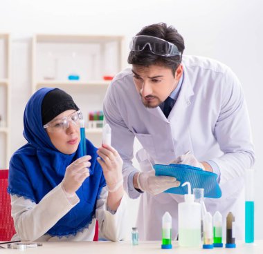 Laboratuvarda çalışan iki kimyager.