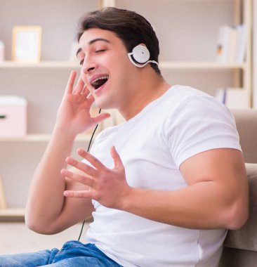 Evde müzik dinleyen genç bir öğrenci.