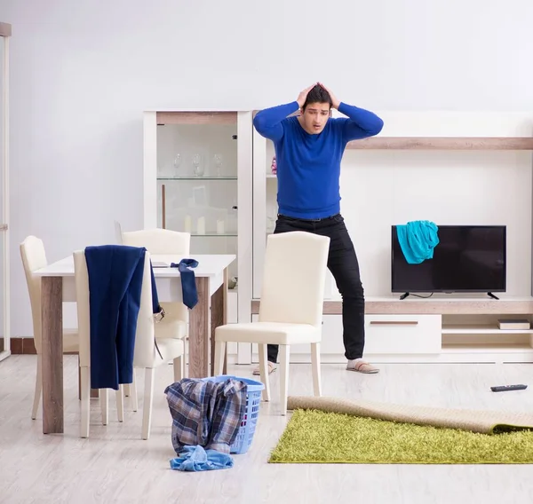 Genç adam çamaşırhane için kirli çamaşır topluyor.