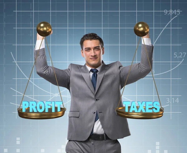 Επιχειρηματίας που συγκρίνει τα κέρδη και τους φόρους — Φωτογραφία Αρχείου
