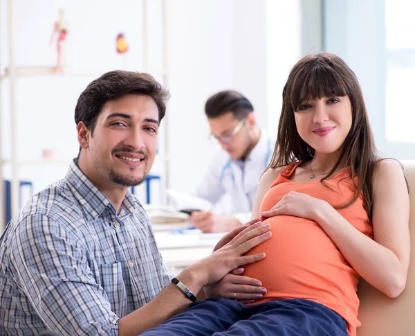 Mulher grávida com o marido visitando o médico na clínica — Fotografia de Stock