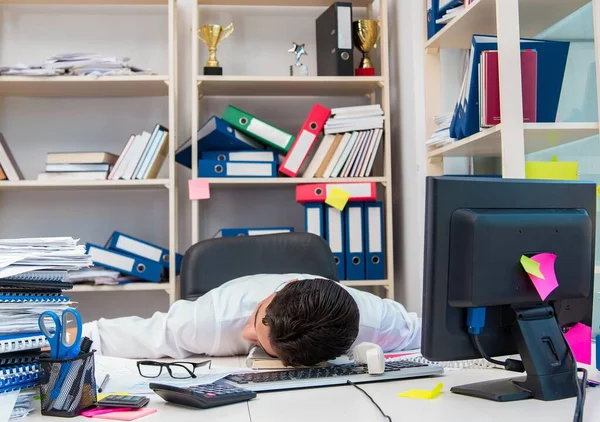 Uomo d'affari che lavora in ufficio con mucchi di libri e carte — Foto Stock