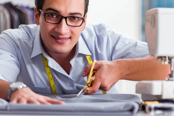 Joven sastre trabajando en ropa nueva —  Fotos de Stock