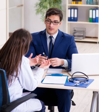 İş adamı doktorla sağlık sorunlarını tartışıyor