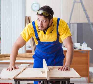 Genç bir marangoz dairesel testere ile çalışıyor.