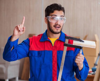 Klemplerle çalışan genç bir tamirci.