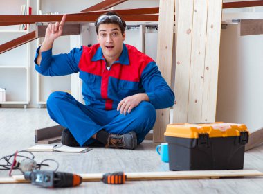 İnşaatta defter planlama yapan genç bir marangoz.