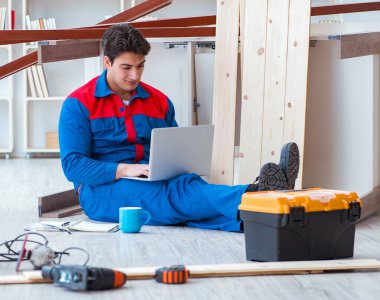 Dizüstü bilgisayarı olan genç bir marangoz