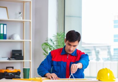 Foreman inşaat planına bakıyor.