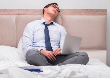 İş adamı evdeki yatakta çalışıyor.