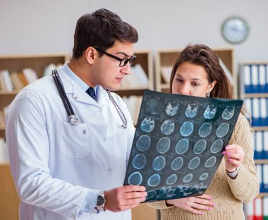 Genç doktor bilgisayardaki röntgen görüntülerine bakıyor.