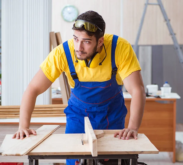 Genç bir marangoz dairesel testere ile çalışıyor.