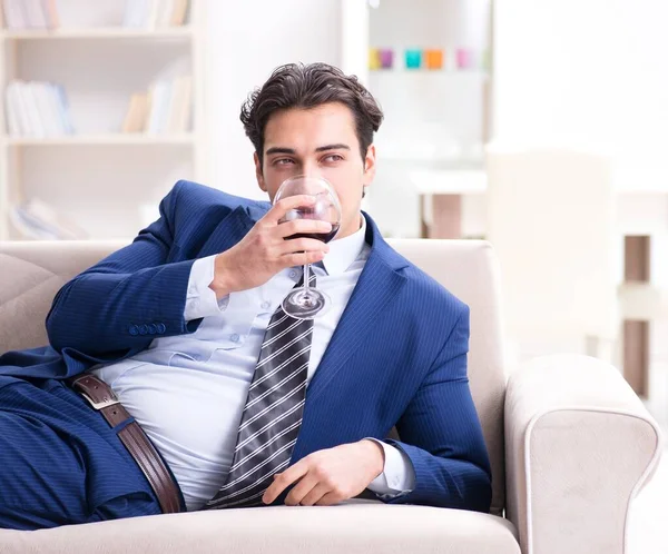 Homme d'affaires buvant du vin assis à la maison — Photo