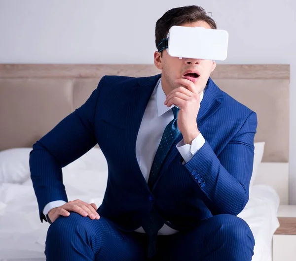 Hombre de negocios con un casco de realidad virtual en el dormitorio — Foto de Stock