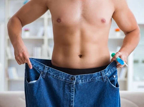 Hombre en pantalones de gran tamaño en concepto de pérdida de peso —  Fotos de Stock