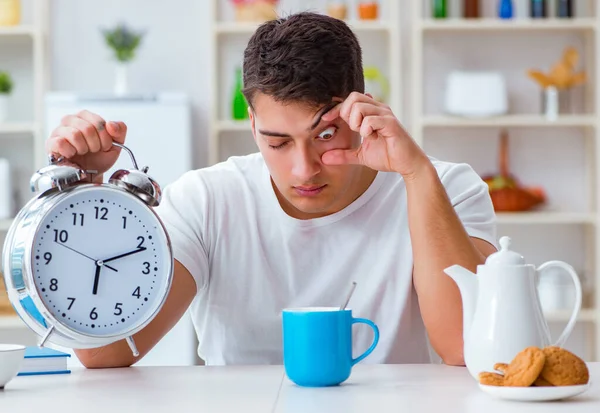 Чоловік з будильником заснув під час сніданку — стокове фото