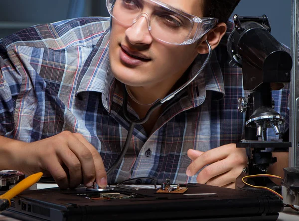 Conceito de reparo de computador com homem inspecionando com estetoscópio — Fotografia de Stock